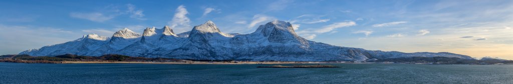 Das Leuchtfeuer auf der Schäre Vikholmen vor der Bergkette der Sieben Schwestern (Sju Søstre) auf der Insel Alsta zwischen Alstenfjorden und Vefsnfjorden, Norwegen, Februar 2015.