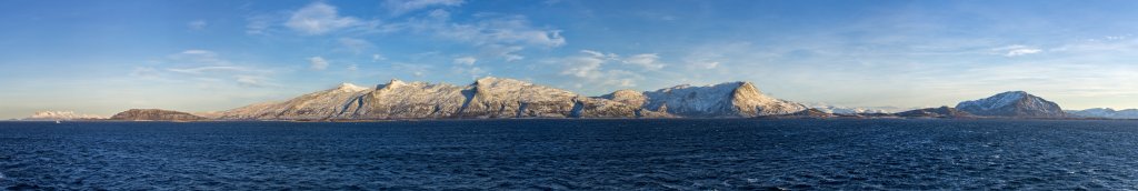 Passage des Ylvingsfjorden mit Kurs auf Brønnøysund und mit Blick auf die Bergkette auf Vevelstad mit dem Snøfjellet (841m), dem Høyholmstindan (1015m), dem Saltkartinden (955m) und dem Hornstinden (885m) sowie dem Mosfjell (526m) auf Sømna, Norwegen, Februar 2015.
