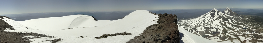 Zoom-Panorama am Gipfel der South Sister (3159m); die grosse Vulkangipfelschau beginnt mit einem breiten Vulkan im Süden der wohl der Mt. McLoughlin (2894m) ist, gefolgt von Middle Sister(3062m), dem deutlich kleineren und wenig schneebedeckten Mt. Washington (2376m), der North Sister (3074m), Mt. Jefferson (3191m), Mt. Hood (3429m) und Mt. Adams (3743m), Three Sisters Wilderness, Oregon