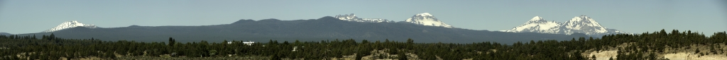 Panorama am HW 20 kurz nach dem Verlassen von Bend in nördlicher Richtung; von diesem Aussichtspunkt direkt am Highway sind zu sehen: Mt. Bachelor (2764m), Broken Top Mountain (2797m), South Sister (3159m), Middle Sister (3062m) und North Sister (3074m), Three Sisters Wilderness, Oregon