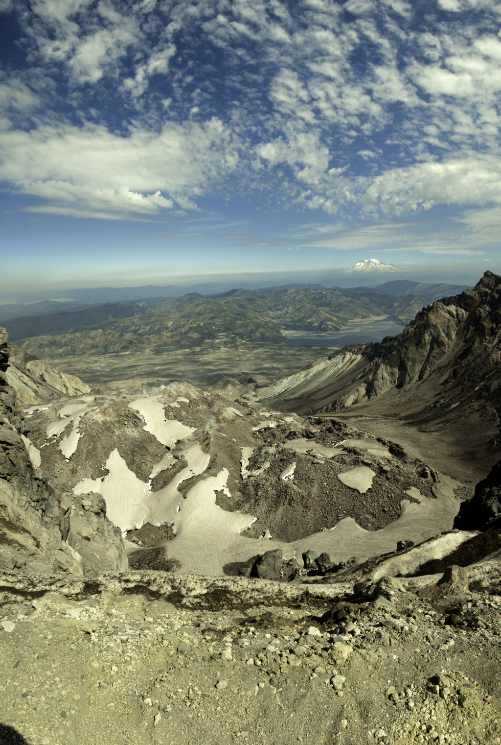 Vertikal-Panorama mit Blick vom s&uuml;dlichen Kraterrand, &uuml;ber den Lava Dome, den Spirit Lake bis zum in der Ferne im Norden aufragenden Mt. Rainier (4359m); auf der hochaufl&ouml;senden Panoramaaufnahme sind deutlich die rauchenden Fumarolen auf dem Lava Dome und der immer noch mit viel Treibholz bedeckte Spirit Lake zu sehen, Mt. St. Helens National Volcanic Monument, Washington
