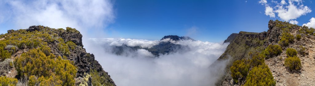 Kurz vor erreichen des Gipfels des Grand Benare (2896m) ist ein Großteil des Cirque de Mafate von Wolken eingehüllt, aus denen der Piton des Neiges (3070m) und der Gros Morne (3013m) steil herausragen, La Reunion, Oktober 2013.