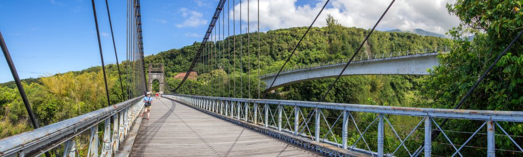 Auf der alten Hängebrücke von 1894 über den Riviere del 'Est, neben der im Jahr 1979 eine moderne Betonspannbrücke errichtet wurde, die heute den Verkehr der Insel-Ringstrasse aufnimmt. Bei diesem Panorama hat mich Panorama-Studio positiv überrascht, dass es die 5 Bilder mit all den Traversen und Drahtseilen mit nur 2 kleinen manuellen Korrekturen fehlerfrei zusammensetzen konnte. Sogar der Schattenwurf der Drahtseile wurde richtig im Panorama abgebildet. La Reunion, Oktober 2013. La Reunion, Oktober 2013.