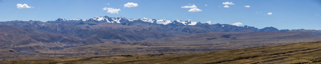 Über weite Pampa-Flächen und das Tal mit den Ortschaften Tinki und Ocongate reicht der Blick bis zum Hauptkamm der Cordillera Vilcanota, Peru, Juli 2014.