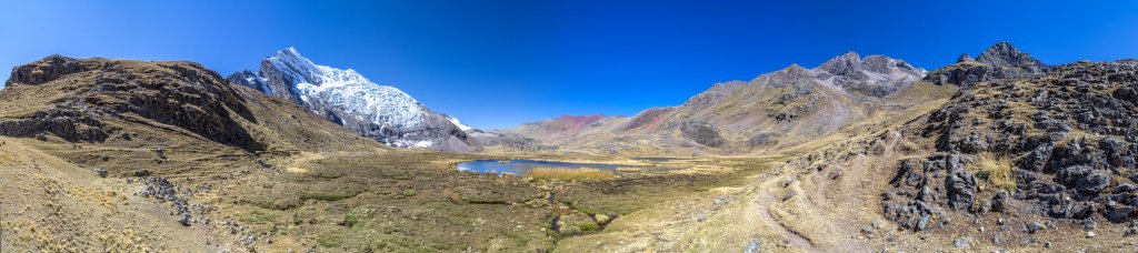 Nach der Überschreitung eines Bergrückens erreichen wir die weite Hochfläche der Laguna Jatun Pucacocha unter der Südseite des Ausangate (6384m), dem Sorinami (5450m) zur Rechten und mit dem ersten Ausblick auf den Alcatani-Pass (4865m), den wir heute noch auf dem Weg zur Laguna Ausangatecocha überschreiten werden, Cordillera Vilcanota, Peru, Juli 2014.