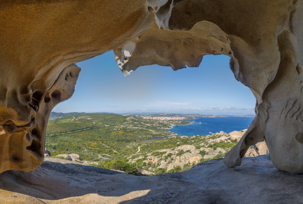 Gewagter Blick zwischen den Beinen des Bären am Capo d'Orso hindurch auf den Hafen und die Bucht von Palau, Sardinien, April 2014.