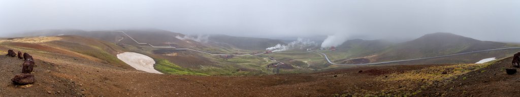 Mistwetter am Geothermalkraftwerk im Krafla-Geothermalgebiet. Insgesamt gibt es hier 17 Hochdruckborhungen, 5 Niederdruckbohrungen und 12 ungenutzte Bohrungen. Die tiefste Bohrung geht auf über 2000 Meter. Unten im Tal ist das rote Hauptgebäude des Kraftwerks zu erkennen, Island, Juli 2015.