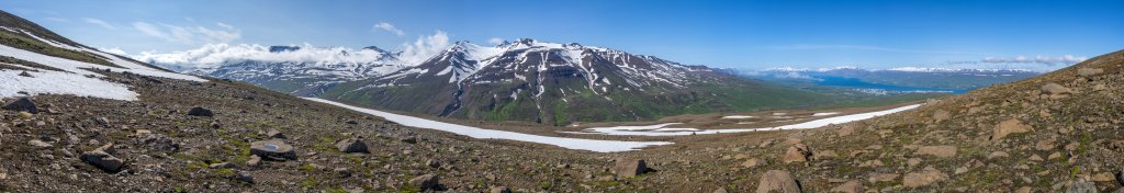 Im Abstieg vom etwas niedrigeren Nordgipfel des Sulur (Ytri-Sula, 1144m) blickt man auf Akureyri am Eyjafjörður und das Glerardalur-Tal mit den gegenüber liegenden Gipfeln von Tröllafjall (1471m), Kista (1474m), Stryta (1456m) und Hliðarfjall, Island, Juli 2015.