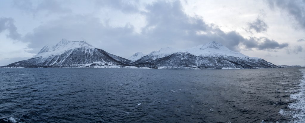Die Bergketten von Bentsjordtinden und Klemmartindan beim Einlaufen in den Straumsfjorden auf dem Weg nach Tromsø, Norwegen, Februar 2015.