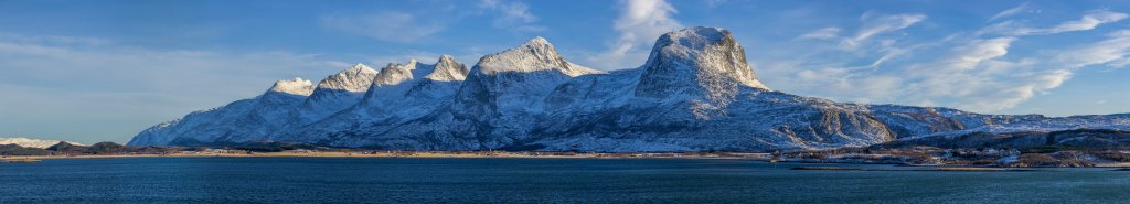 Ein letzter Blick auf die von der Sonne angestrahlte Bergkette der Sieben Schwestern (Sju Søstre) bei der Passage des Alstahaugfjorden an der Südspitze der Insel Alsta, Norwegen, Februar 2015.