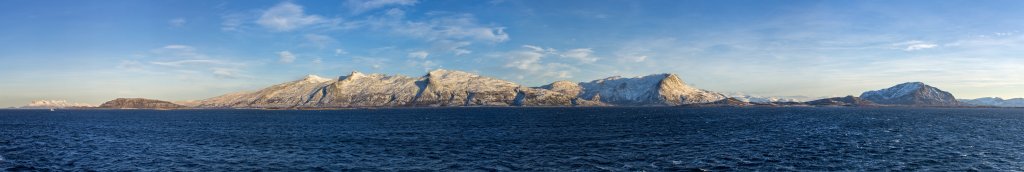 Passage des Ylvingsfjorden mit Kurs auf Brønnøysund und mit Blick auf die Bergkette auf Vevelstad mit dem Snøfjellet (841m), dem Høyholmstindan (1015m), dem Saltkartinden (955m) und dem Hornstinden (885m) sowie dem Mosfjell (526m) auf Sømna, Norwegen, Februar 2015.