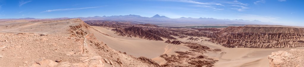 Blick vom nordwestlichen Rand des Valle de la Muerte auf die wild zerklüftete Felsenlandschaft und die großen Sanddünen des Tals. In Bildmitte erkennt man den Berg der Felsenfestung Quitor und darüber den Vulkankegel des Licancabur (5920m), Chile, November 2016.
