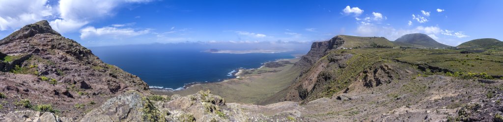 Blick vom 500m hohen Famara-Cliff bei der Ortschaft Guinate an der Nordküste Lanzarotes auf die Steilküste und die vorgelagerte Insel La Graciosa, Lanzarote, Kanarische Inseln, März 2017.
