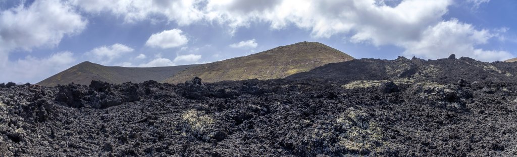 Schwarzer Lavafluss vor dem Rundkrater der Caldera Blanca, Lanzarote, Kanarische Inseln, März 2017.