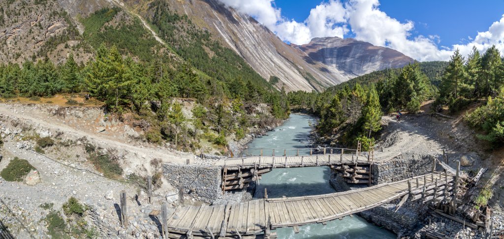 Drei Generationen von Brücken direkt nebeneinander - 2 mal Holz und eine moderne Suspension Bridge. Auf dem Weg von Dhuker Pokhari nach Upper Pisang unter den beeindruckenden Gletscherschliffwänden des Swargadwari Danda (4895m), Nepal, Oktober 2017.