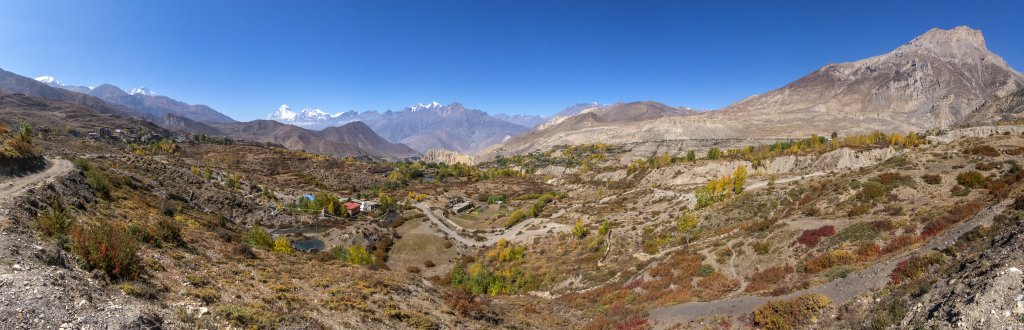 Panorama über Muktinath von unterhalb des Buddhistischen Tempel- und Klosterbezirks mit Blick auf Tilicho Peak (7134m), Nilgiri North (7061m), Dhaulagiri (8167m), Tukuche Peak (6920m) und den Sangdachhe Himal (6403m), Nepal, Oktober 2017.
