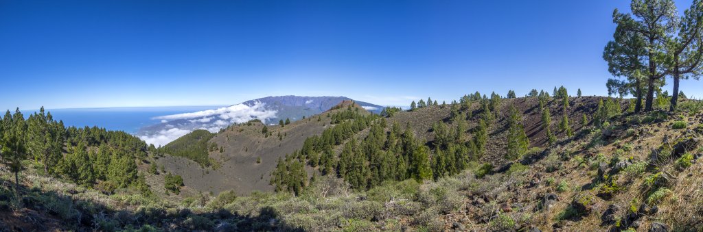Blick vom Montana la Barquite (1809m) auf San Juan (1658m) und Pico Birigoyo (1808m) vor dem imposant hoch aufragenden Gipfel des Pico Bejenado (1854m) und des Rands der Caldera del Taburiente, La Palma, Kanarische Inseln, Februar/März 2018.