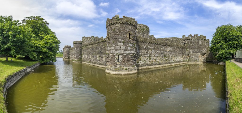 Wassergraben und äußere Ringmauer der Englischen Festung Beaumaris Castle aus dem 13. Jahrhundert auf der Insel Anglesey, Wales, Großbritannien, Juni 2018.