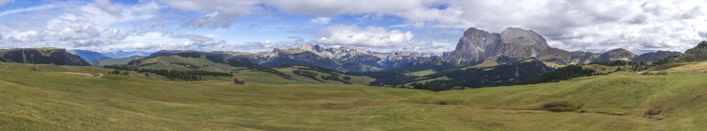 Weite Seiseralm mit Blick zum Zillertaler Hauptkamm, der Puez-Geisler-Gruppe mit dem markanten Sass Rigais sowie dem Lang- und Plattkofel, Seiseralm, Südtirol, Oktober 2019.