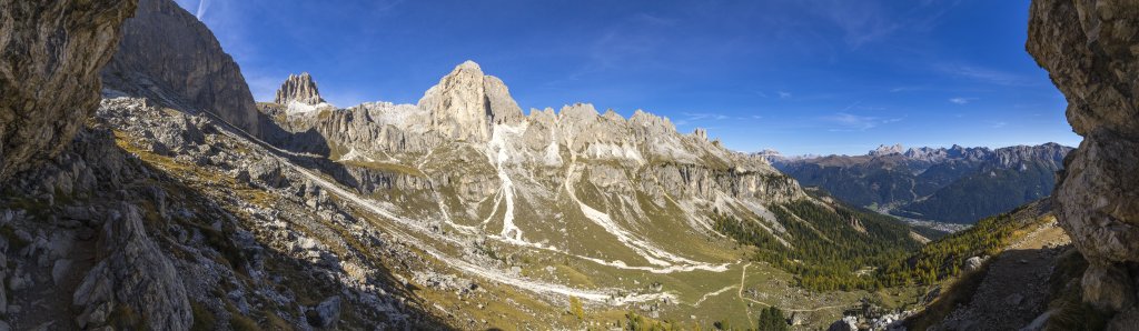 Panorama unterhalb der Rotwand mit Blick auf den Mugoni (2734m), die Cigolade (2540m), die Pale Rabbiose gefolgt in der Ferne vom Sellastock mit dem Piz Boe und den Südwänden der Marmolada hoch über dem Fassa-Tal, Rosengarten, Südtirol, Oktober 2019.