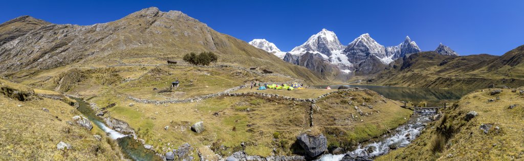 Traumhaft gelegenes Camp am Ufer der Laguna Carhuacocha auf 4156m Höhe mit Blick auf die Hauptgipfel der Cordillera Huayhuash - Siula Grande (6344m), Yerupaja (6635m), Yerupaja Chico (6121m), Jirishanca (6094m) und Rondoy (5775m), Peru, Juli 2019.