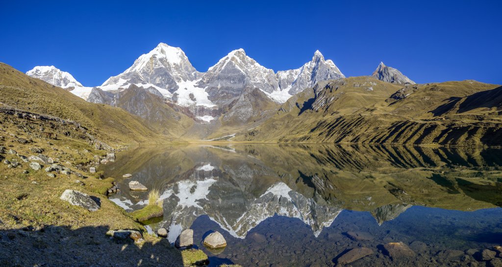 Im Morgenlicht spiegeln sich die höchsten Berge der Cordillera Huayhuash in der Laguna Carhuacocha, Peru, Juli 2019.