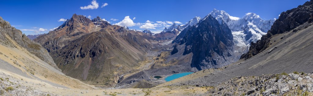 Über der Laguna Juraucocha hat man einen tiefen Blick in das Tal der Quebrada Sarapococha und auf die sich darüber erhebenden Gipfel des Cerro Rosario (5557m), Tsacra Grande (5610m), Tsacra Chico (5548m), Nevado Rasac (6017m), Yerupaja (6635m), Siula Grande (6344m), Nevado Sarapo (6127m) und des Nevado Carnicero (5960m), Peru, Juli 2019.