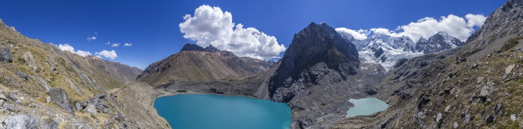 Panorama von der Randmoräne der Laguna Juraucocha mit Blick auf den Cerro Rosario (5557m), einen namenlosen Felsgipfel (5453m) direkt vis-a-vis, den sich in der Wolke darüber versteckenden Nevado Sarapo (6127m), den Carnicero (5960m) gefolgt von der Kette der Gipfel Jurau D (5674m), Jurau E/Huaraca (5537m) und Jurau F/Quesillo (5600m) und abgeschlossen vom Gipfel des Nevado Trapecio (5653m), Peru, Juli 2019.