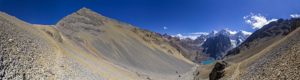 Steiler Geröllabstieg vom Paso San Antonio (5065m) zur Laguna Juraucocha mit Blick auf das Tal der Quebrada Sarapococha, wo sich das Basislager für den Siula Grande befindet, und die sich darüber erhebenden Gipfel des Tsacra Grande (5610m), Tsacra Chico (5548m), Nevado Rasac (6017m), Yerupaja (6635m), Siula Grande (6344m), Nevado Sarapo (6127m) und des Nevado Carnicero (5960m), Peru, Juli 2019.