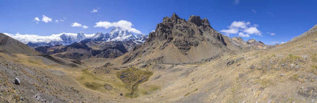 Direkt nach der Überschreitung des Passes Llaucha Punta (4838m) verdeckt noch ein namenloser 5000-er und eine Fönwolkenwalze ein wenig die zu erahnende Szenerie. Aber der Blick wird frei auf den Norden der Cordillera Huayhuash mit dem Ninashanca (5607m), Rondoy Chico (5500m), Rondoy (5775m), Jirishanca (6094m), Yerupaja Chico (6121m) und dem alles überragenden Yerupaja (6635m), Peru, Juli 2019.