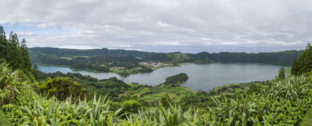 Blick vom Miradouro Do Cerrado Das Freiras auf den Ort und die Vulkanseen-Landschaft von Sete Cidades mit dem Lagoa Verde und dem Lagoa Azul, Sao Miguel, Azoren, Portugal, September 2022.
