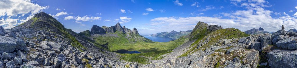Panorama aus dem Sattel zwischen dem Gipfel des Hesten (556m) und des Stavelitippen (520m) mit Blick auf die Felsengruppe und Gipfel des Inste-Kongen (738m), Ytste-Kongen (750m) und Svartevasstinden (614m) hoch über dem Oyfjorden, Norwegen, Juli 2022.
