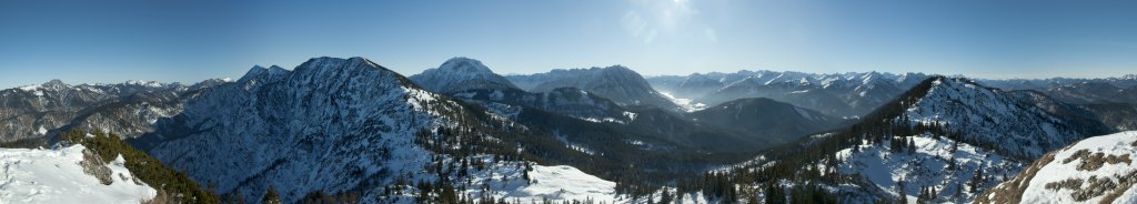 Panorama vom Gipfel des Schildensteins in Richtung Süden. Im Nordosten liegt der Tegernsee mit den ihn begrenzenden Bergen gefolgt von Risserkogel, Halserspitze, dem Kamm der Blauberge über der Wolfsschlucht, dem Guffert, Rofan und Unnütz, Achensee und Seebergspitze/Seekarspitze, Karwendelberge und Juifen sowie ganz im Westen der Wetterstein und die Zugspitze. Mangfallgebirge, Januar 2010.