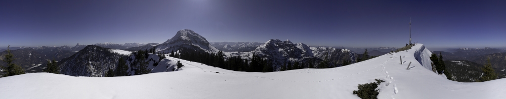 360-Grad-Panorama vom Gipfel des Pitzkopfes (1670m) mit Blick auf Wallberg/Setzberg/Risserkogel, den Kamm der Blauberge mit Halserspitz, Guffert, Schulterberg, Unnütz, das Rofan, Hochplatte und Seekofel, Juifen, Rotwandalmen mit dahinterliegendem Karwendelgebirge, Zotenjoch, Demeljoch, Dürrenbergjoch, Estergebirge mit Krottenkopf, Simetsberg, Heimgarten & Herzogstand, Hirschhörndlkopf, Rabenkopf, Glaswand, Benediktenwand, Gipfel des Pitzkopfes mit Gipfelkreuz, Schönberg, Hochplatte, Ross- & Buchstein und Leonhardtstein, Nördliches Karwendel, März 2011.