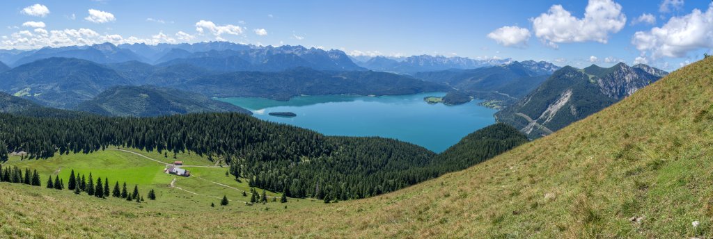 Blick vom Gipfel des Jochbergs (1565m) auf Jocheralm und Walchensee sowie die Gebirgsketten des Karwendel, des Soierngebirges, des Wettersteins und des Estergebirges mit dem nahen Herzogstand und Heimgarten, Mangfallgebirge, Bayrische Voralpen, August 2014.