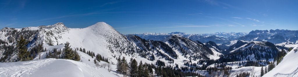 Am Gipfel der Mühlhornwand (1658m) mit Blick auf Roßalpenkopf, Geigelstein, Loferer Steinberge, Kitzbüheler Alpen, Hohe Tauern und den Wilden Kaiser, Chiemgauer Alpen, März 2015.