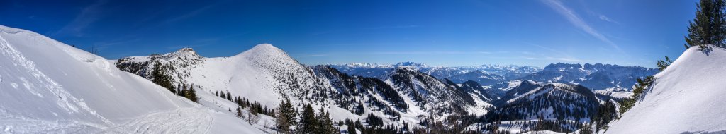 Am Gipfel der Mühlhornwand (1658m) mit Blick auf den Roßalpenkopf (1762m), den Geigelstein (1808m), den Breitenstein (1661m), die Loferer Steinberge, die Hohen Tauern, Kitzbüheler Alpen sowie den Zahmen und Wilden Kaiser, Chiemgauer Alpen, März 2015.