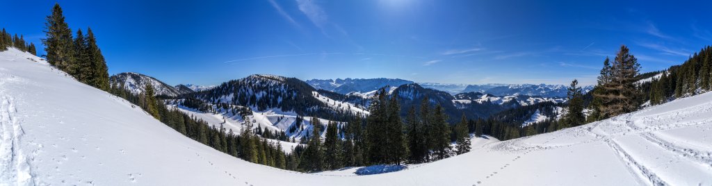 Panorama nahe der Schreckalm (1399m) mit Blick auf Breitenstein (1661m), Hochköpfl (1539m), Wilden und Zahmen Kaiser, Wandberg (1554m) und das Mangfallgebirge über dem Inntal, Chiemgauer Alpen, März 2015.