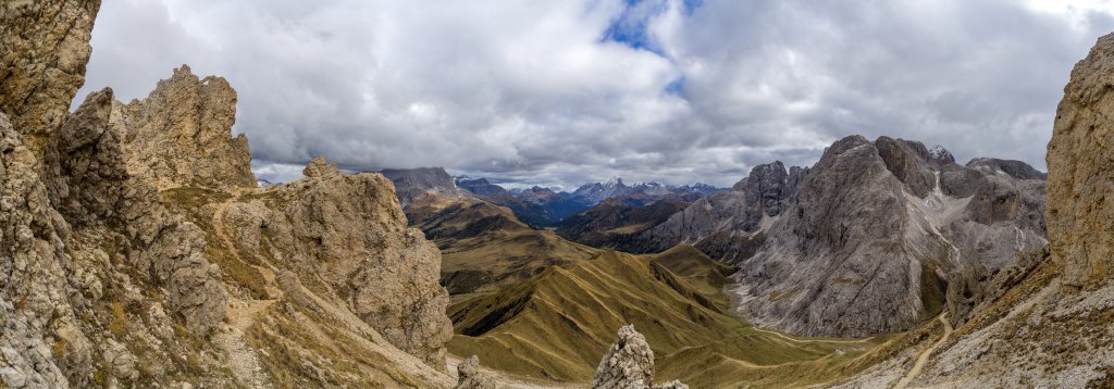 Am Übergang über die Roßzähn-Scharte (2499m) eröffnet sich ein Ausblick auf den wolkenverhangenen Plattkofel, die Sella mit dem Piz Boe (3152m) die Marmolada und die Croda del Lago (2806m) im nördlichen Rosengarten, Seiseralm, Oktober 2015.