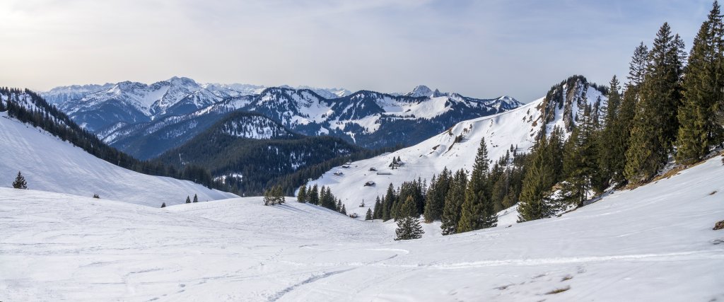 Blick auf die Schönfeldalmen unterhalb des Jägerkampl im Spitzingseegebiet, dahinter der Österreichische und Bayrische Schinder, der Guffert, der Kamm von Stümpfling, Roßkopf und Stolzenberg sowie der Schilden- und Blankenstein, Mangfallgebirge, Bayrische Alpen, Februar 2017.