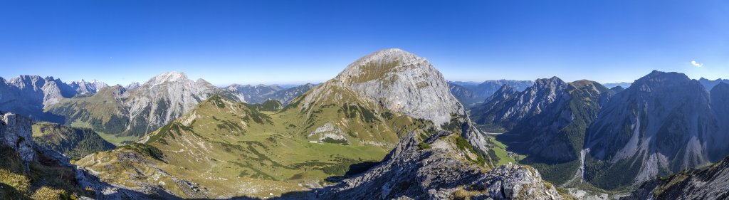 Gipfelpanorama auf der Hahnkampl-Spitze (2080m) gen Osten mit Blick auf Laliderer Wände, Gumpenspitze (2176m), Gamsjoch (2452m), Grameijoch (2017m), das massige und hohe Sonnjoch (2458m), das Rofan und das tief eingeschnittene Karwendeltal der Gramei-Alm, Rappenspitze (2223m), Lunstkopf (2142m) und Rauher Knöll (2277m), Karwendel, September 2018.