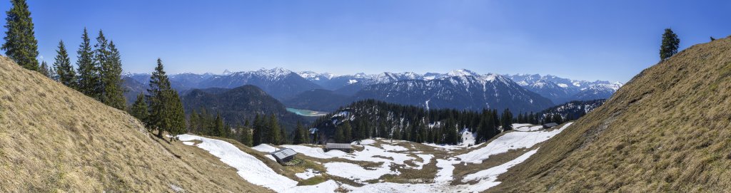 Panorama oberhalb der Staffelalm auf 1460m Höhe mit Blick nach Süden auf den Guffert, Juifen und Demeljoch, Mondscheinspitze, Schafreuther, Grasköpfl und Vorderskopf sowie die dahinter aufragenden Karwendelberge, Jachenau, Bayrische Alpen, April 2019.