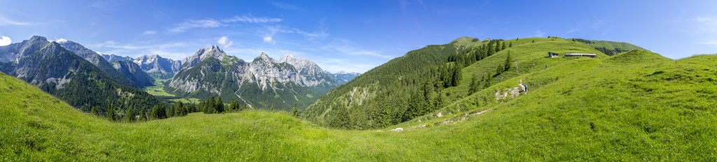 Blick vom Aufstieg an den Hasentalalmen hinunter auf Großen Ahornboden und in die Eng mit ihren hohen umgebenden Karwendelbergen wie Schaufelspitze, Sonnjoch, Stoanblamlkopf, Schafkarspitze, Spritzkarspitze, Gamsjoch und Rüderkarspitze, Laliderer Falk und Risserfalk, über uns der Kompar und das Satteljoch, Karwendel, Juli 2021.