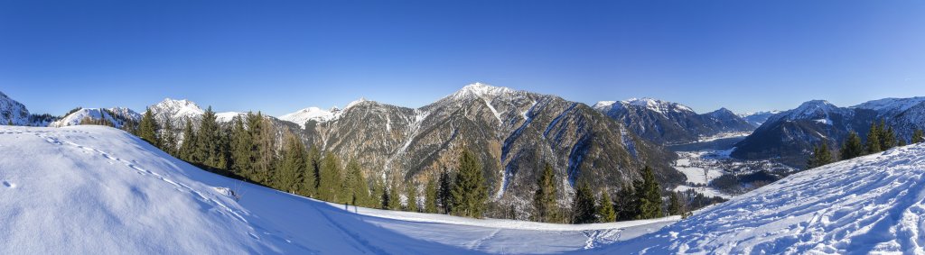 Am Gipfel des Feilkopfs mit Blick auf Montscheinspitze, Schleimsjoch, Seebergspitze, das Rofan, Achensee und Pertisau, Ebner Joch und Bärenkopf, Karwendel, Januar 2022.